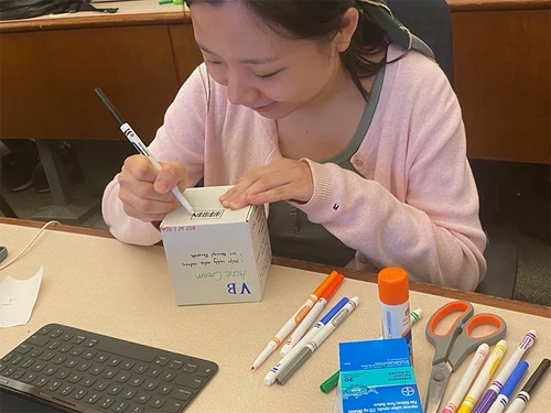 Northeastern University student drawing FDA labeling requirements with crayons in Angela Johnson's hands-on seminar